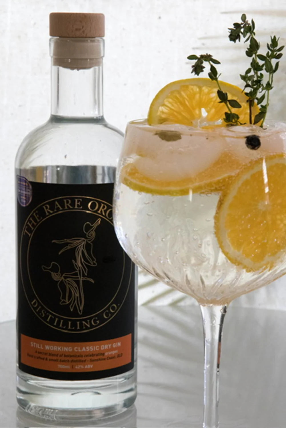 Still Working Classic Dry Gin, real bottle beside a citrus and thyme gin and tonic